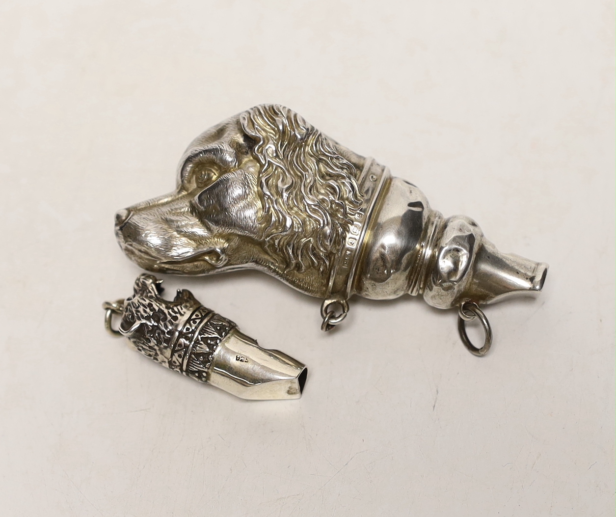 An Edwardian novelty silver whistle, modelled as a dog's head, Crisford & Norris, Birmingham, 1904, 76mm, together with a smaller modern 925 'leopard's head' whistle.